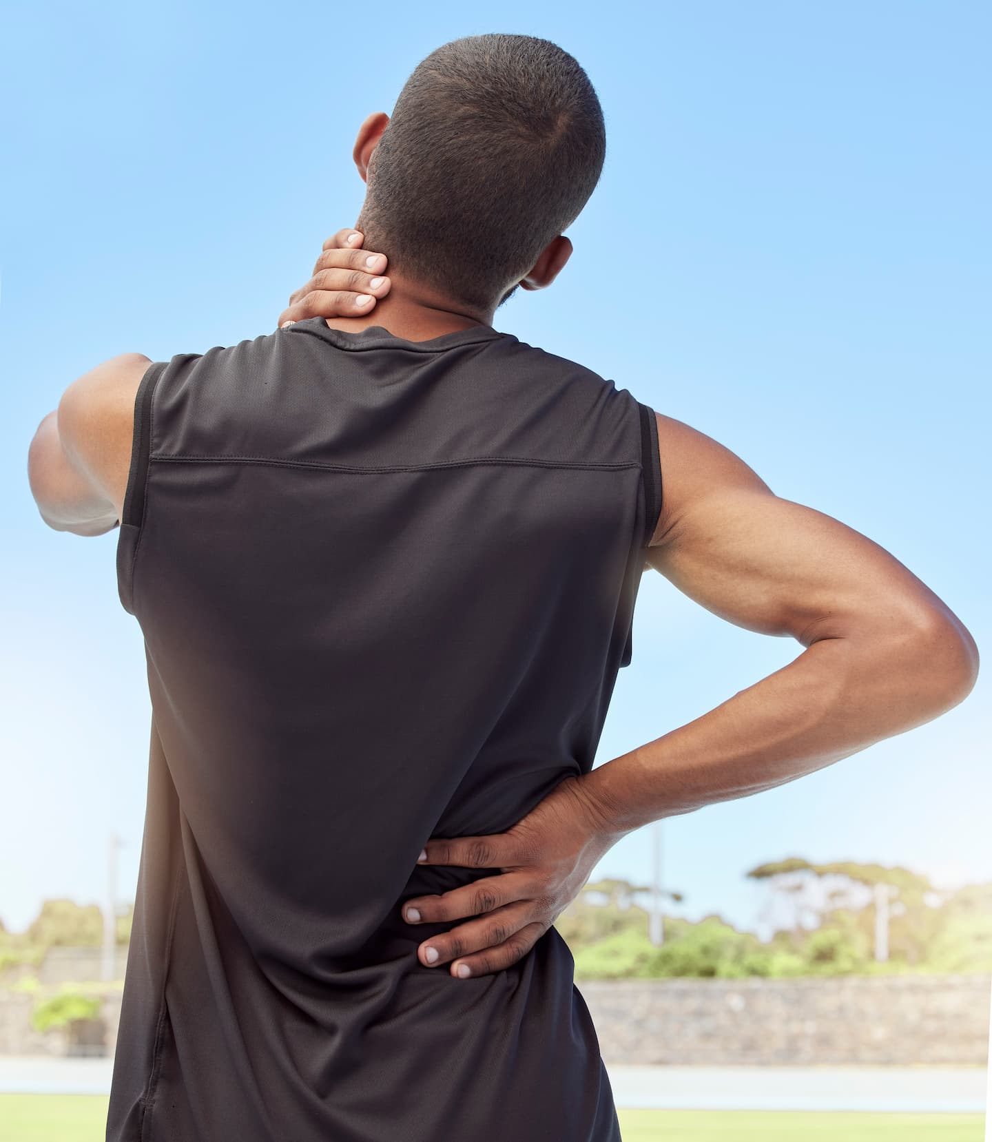 rearview-athlete-with-neck-pain-closeup-back-view-uncomfortable-young-sportsman-standing-sport-field-holding-his-stiff-inflamed-joints-muscle-strain-due-injury-1.jpg